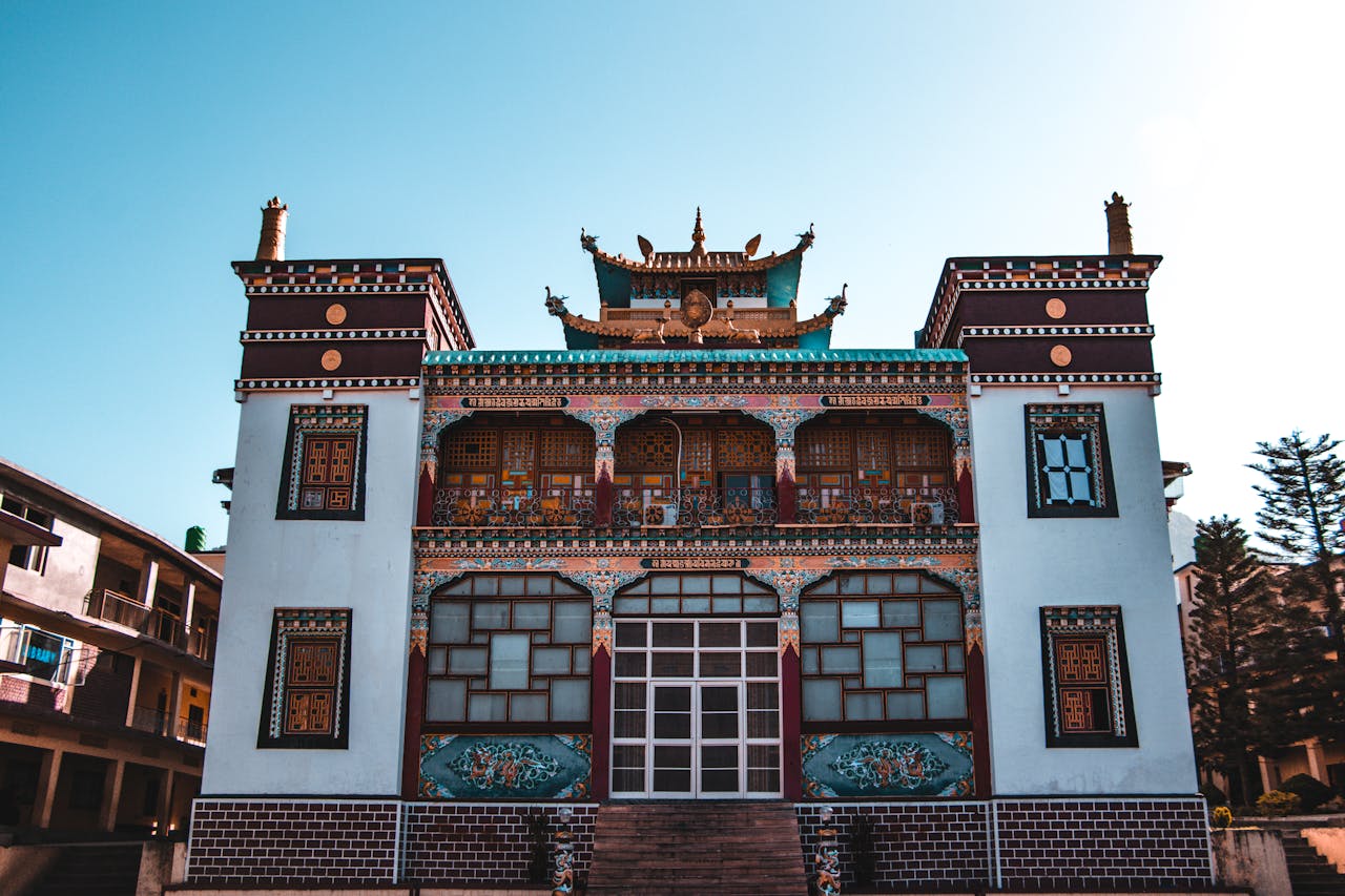 A vibrant Buddhist temple exterior showcasing traditional architecture under clear blue skies.
