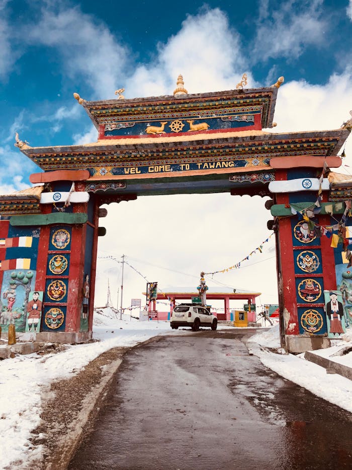 Explore the vibrant Tawang gate amidst snow, capturing traditional architecture and scenic beauty.
