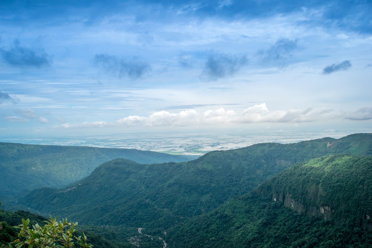 Stunning aerial landscape of lush green mountains and expansive sky, capturing natural beauty and serenity.